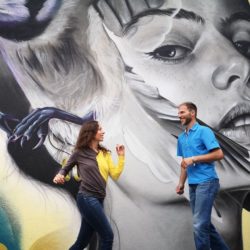 Nadine und Jörg tanzen Solo Latin vor einem Wandgrafiti