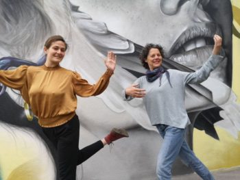 Lucia und Claudia tanzen Solo Tango vor einem coolen Wandgrafiti