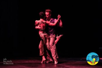 dunkler Hintergrund, ein rosa beleuchtetes Paar tanzt Tango